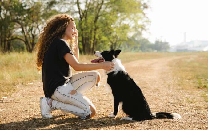 Woman knees as she pets a dog