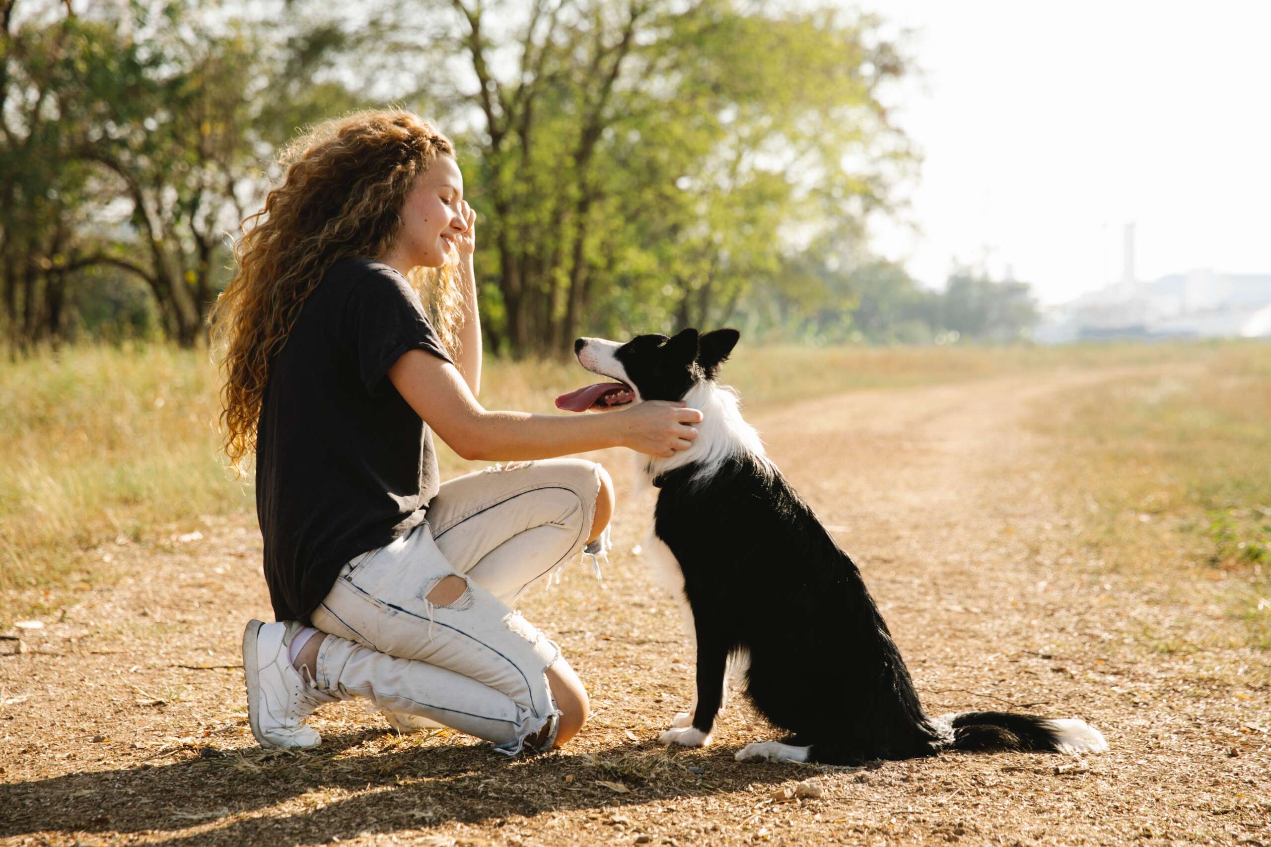 Woman knees as she pets a dog