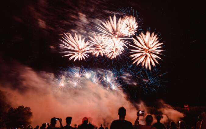 A night sky is filled with fireworks as the crowd looks up at them